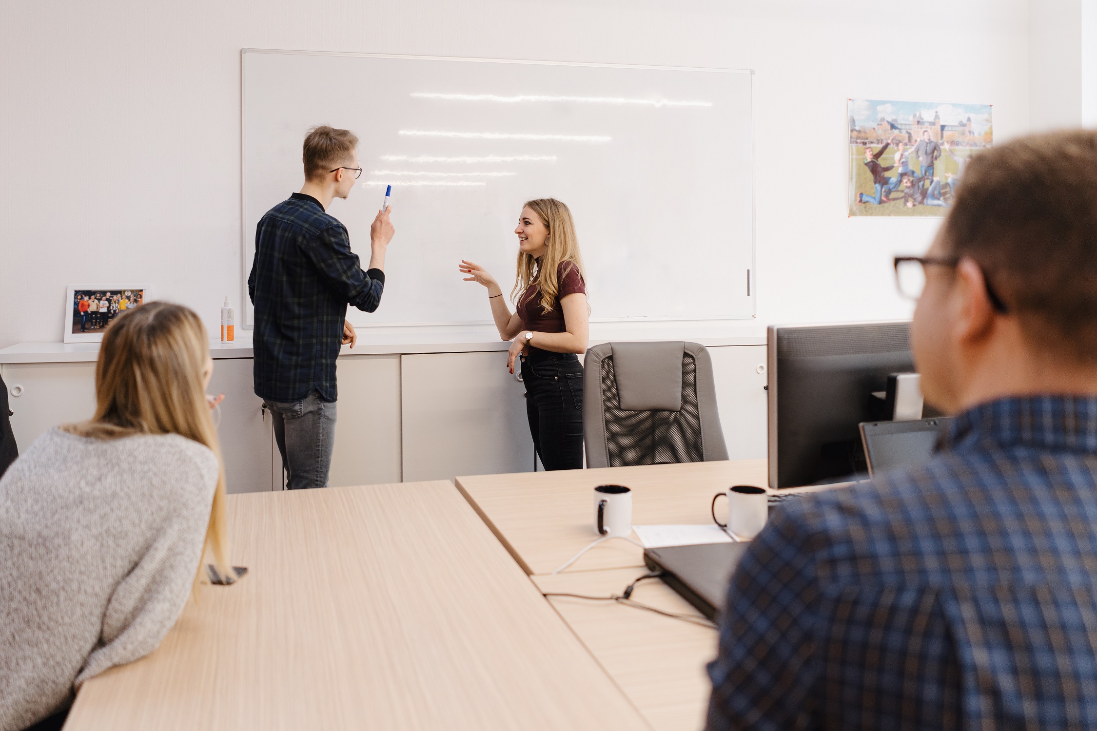young businessman discussing with colleagues whiteboard office 2 young businessman discussing with colleagues whiteboard office 2